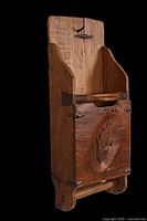 Angled front-left view showing carving, backboard, and overall form