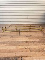 Full view of brass fireplace fender on wood floor