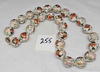 Full view of knotted porcelain bead necklace with length indicator tag