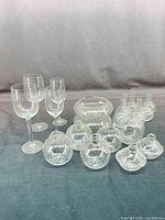 Group shot of all clear glass pieces: wine glasses, bowl, various bud vases