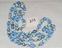 Full view of coiled necklace showing variety of blue glass beads