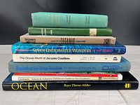 Stack of nine ocean-themed books, spines showing titles and authors