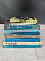 Stack of eight marine-themed books showing titles on spines