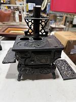 Front angled view showing overall stove, burner plates, chimney, side shelf