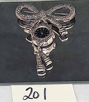 Front view of sterling silver marcasite bow brooch with hanging watch