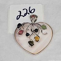 Front view of heart pendant showing pink quartz base, silver vine, six colored stones, and bail