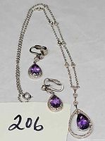 Full view of necklace and both earrings showing design and stones