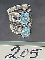 Front view of ring showing center blue topaz and accent stones