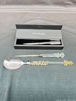 Overall view of three items: boxed Reed & Barton letter opener, crystal handle letter opener, art glass serving spoon