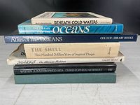 Seven stacked books showing spines and titles