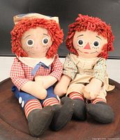 Front view of both Raggedy Ann and Andy dolls seated