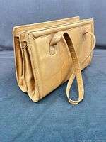 Side view showing tan leather, handles, double gusset