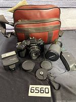 Full lot showing camera, lenses, flash, caps, cloth and bag