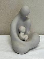Front view of cast stone abstract mother and child sculpture