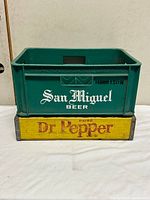 Front view of San Miguel crate stacked on Dr Pepper divider