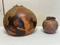 Front view of both pieces showing size comparison and surface decoration