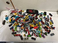 Pile of approximately 100 loose diecast vehicles on table