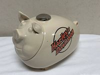 Side view of cream ceramic pig cookie jar with Harley-Davidson logo