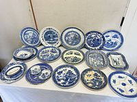 Full lot showing 20 blue and white transferware plates and dishes on table