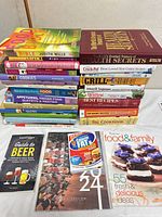 Full lot showing stacks of cookbooks plus magazines in foreground
