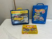 Front view of all three vintage car carry cases showing graphics and handles