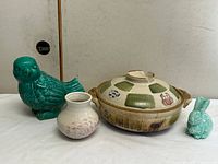 Group shot of casserole with lid, parrot figurine, bud vase, rabbit figurine