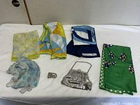 Group shot of five scarves, belt buckle and evening purse