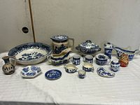 Entire lot arranged on table showing all blue & white transferware items and red figure