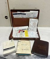 Overall lot with case open, charts and three manuals displayed