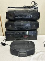 Stacked view of four boomboxes showing overall forms and cords