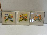 All three framed floral paintings side by side