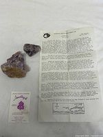 Full lot showing two amethyst clusters, information sheet and card