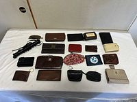All wallets, coin purses, whip and hair clip laid out on table