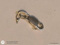 Top view of sterling silver lobster clasp showing overall shape and attached ring