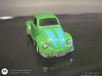 Front three-quarter view showing green body, blue hood stripes, headlights, bumper