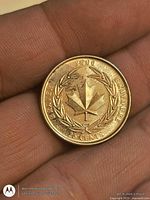 Reverse of 2000 Canadian 25-cent coin showing maple leaf and laurel wreath