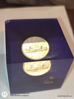 Front view of blue acrylic cube showing embedded Canadian dollar coin