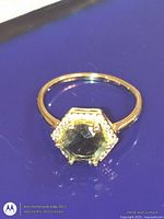 Top view of gold-tone ring with hexagonal halo setting and stones