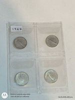 Front of holder showing four coins, fish side visible