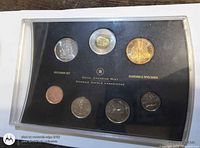 Front view of sealed specimen set showing all seven coins in display case