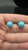 Front view of both turquoise cabochon stud earrings