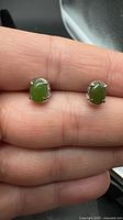 Front view of both jade stud earrings showing cabochons and prong settings