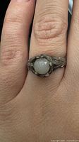 Ring on finger showing moonstone cabochon and band