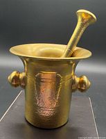 Front view of brass mortar with pestle inserted