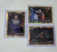 Three Topps Chrome Sapphire Gold parallel cards in top loaders