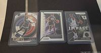 Front view of three Anthony Edwards rookie cards in sleeves and top loaders