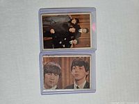 Fronts of both Beatles trading cards in sleeves