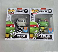 Front view of both boxed Raphael #31 figures showing CHASE and PX stickers