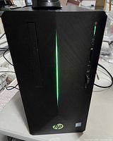 Front of HP Pavilion Gaming Desktop tower showing green LED, optical drive slot, ports and power button