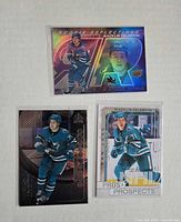 Fronts of three Macklin Celebrini rookie cards